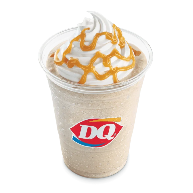 Caramel MooLatte in a clear cup with whipped topping and straw