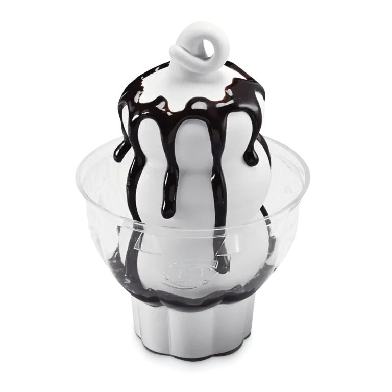vanilla soft serve sundae topped with chocolate sauce in a white cup
