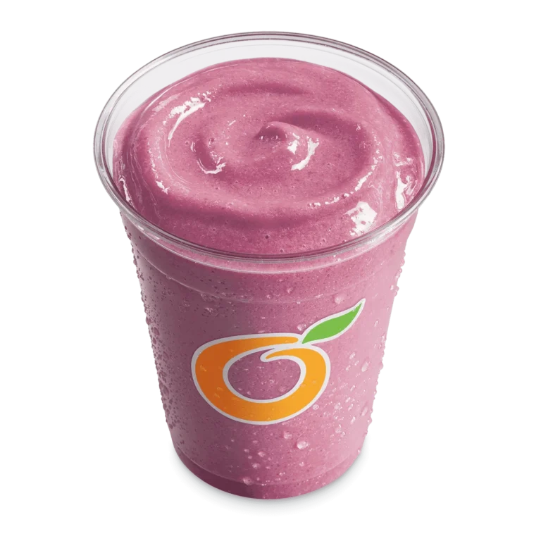 Tall clear cup filled with purple triple berry fruit smoothie with a straw