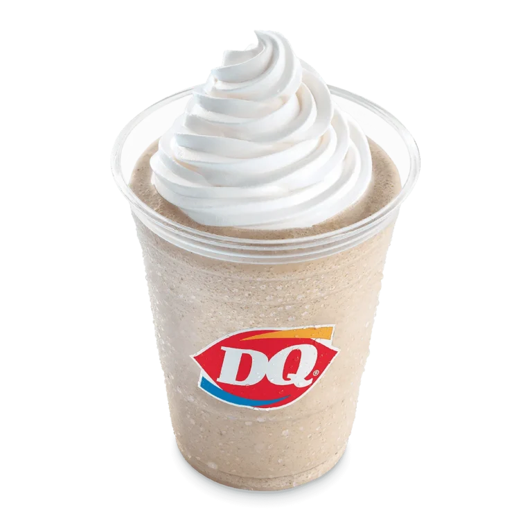 Vanilla MooLatte in a clear cup with whipped topping and straw