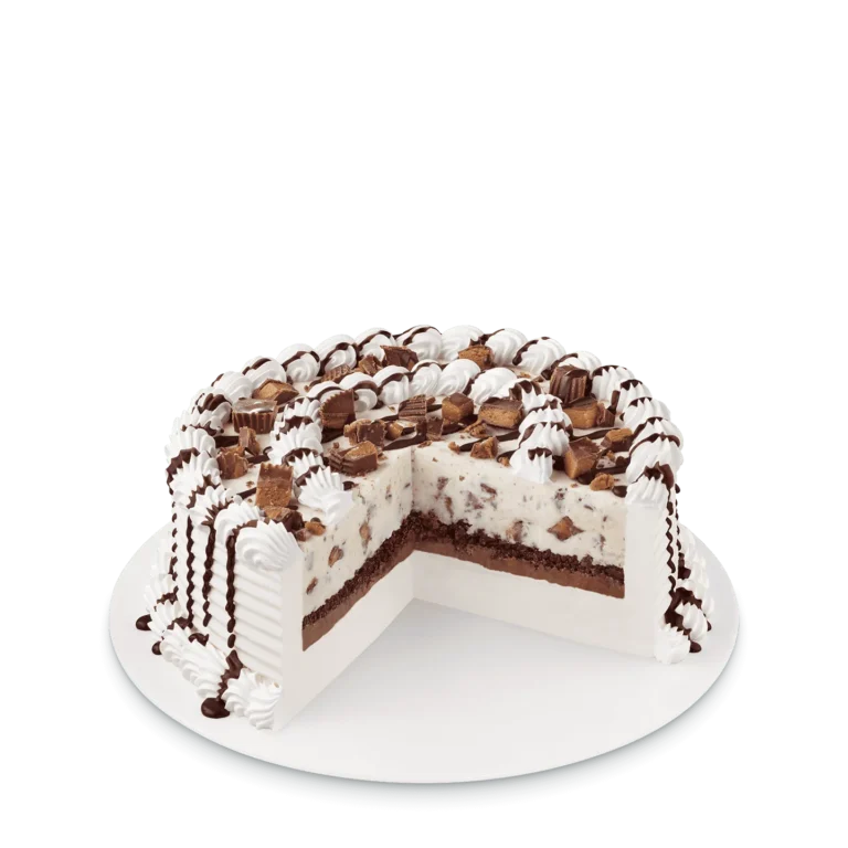 round cake with peanut butter cup pieces and peanut butter drizzle on top